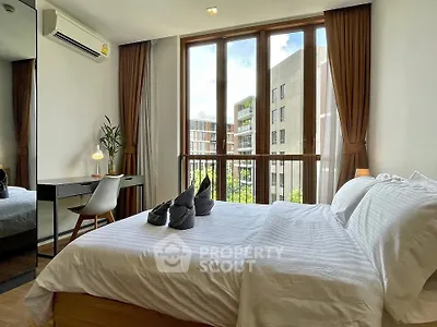 Modern bedroom with large window and stylish decor in urban apartment