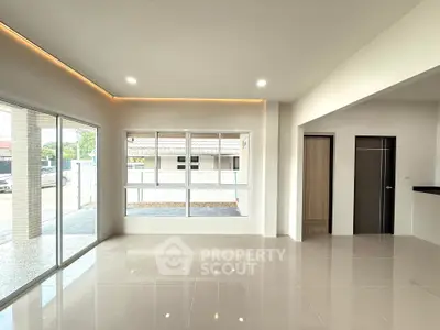 Spacious modern living room with large windows and sleek tile flooring