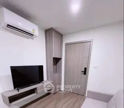 Modern living room with sleek TV unit and air conditioning in a cozy apartment.