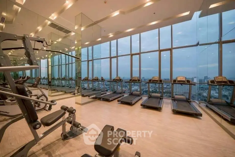 Luxurious high-rise gym with panoramic city views and modern fitness equipment.