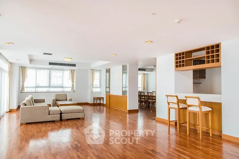 Spacious open-plan living room with hardwood floors and modern furniture