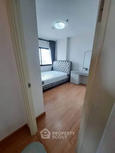 Cozy bedroom with modern decor and natural light in a stylish apartment.