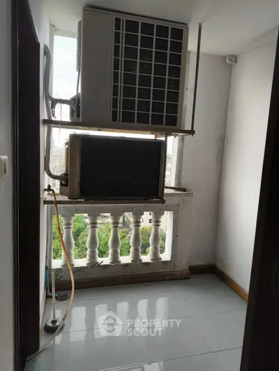 Compact balcony with air conditioning units and city view