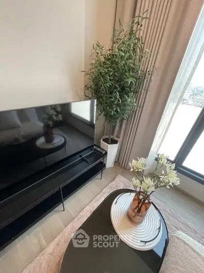 Modern living room with sleek TV, stylish coffee table, and elegant decor