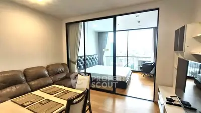 Modern apartment with open living and bedroom space featuring large windows and stylish furniture.