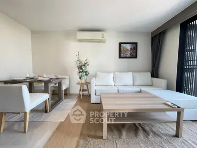 Modern living room with white sofa, dining table, and air conditioning