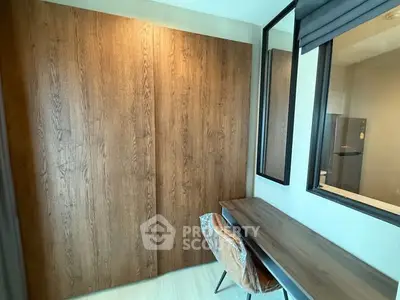 Modern study room with wooden desk and stylish chair, featuring large wooden wardrobe.