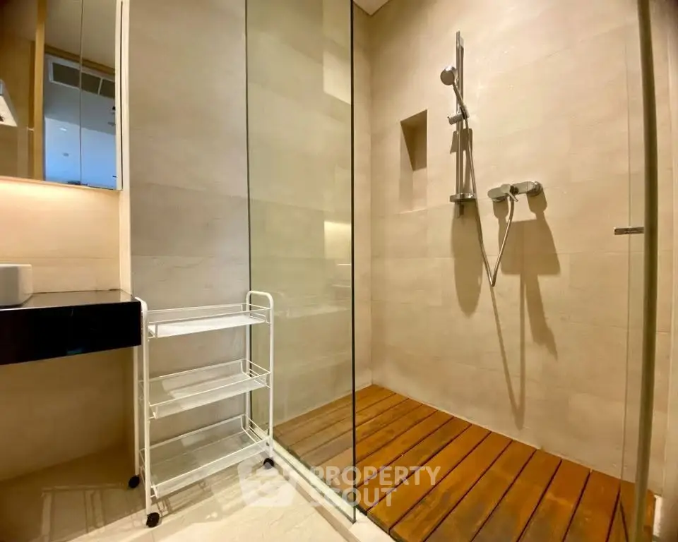 Modern bathroom with glass shower and wooden floor accents