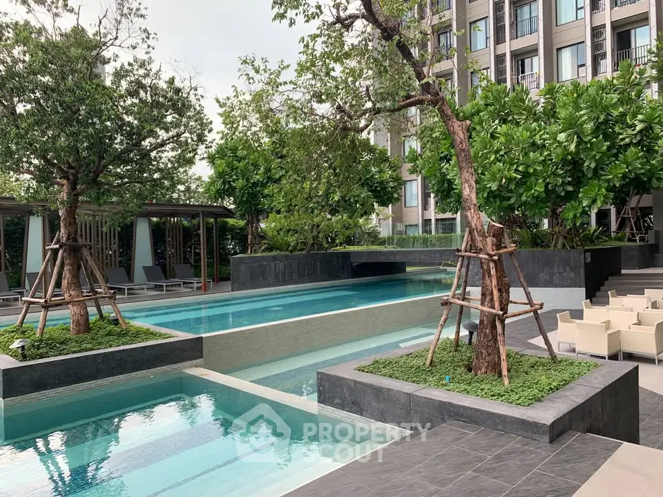Luxurious condominium pool area with lush greenery and modern design
