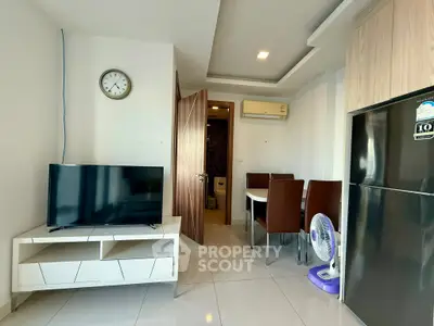 Modern living room with dining area and sleek appliances in a cozy apartment.