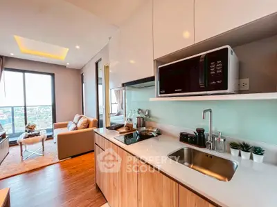 Modern open-layout kitchen with sleek appliances and cozy living area with city view.