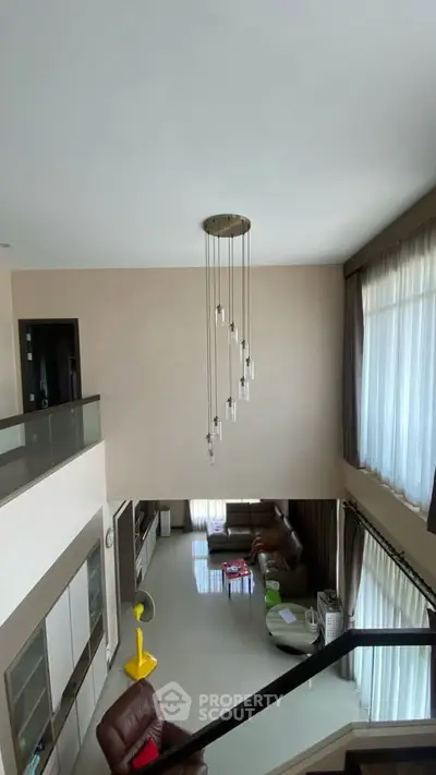 Spacious modern living room with high ceiling and elegant chandelier