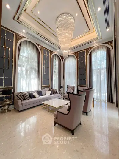 Luxurious high-ceiling living room with elegant chandelier and modern furnishings.