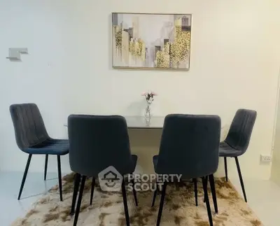 Modern dining area with stylish chairs and elegant wall art in a cozy apartment setting.