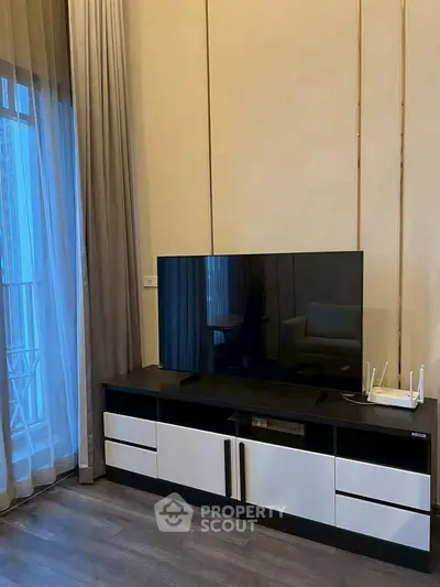 Modern living room with sleek TV stand and large window with curtains