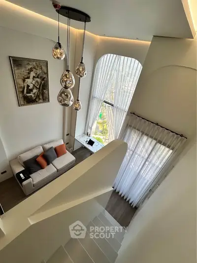 Stunning modern living room with high ceilings and elegant lighting, featuring a large window with city view.