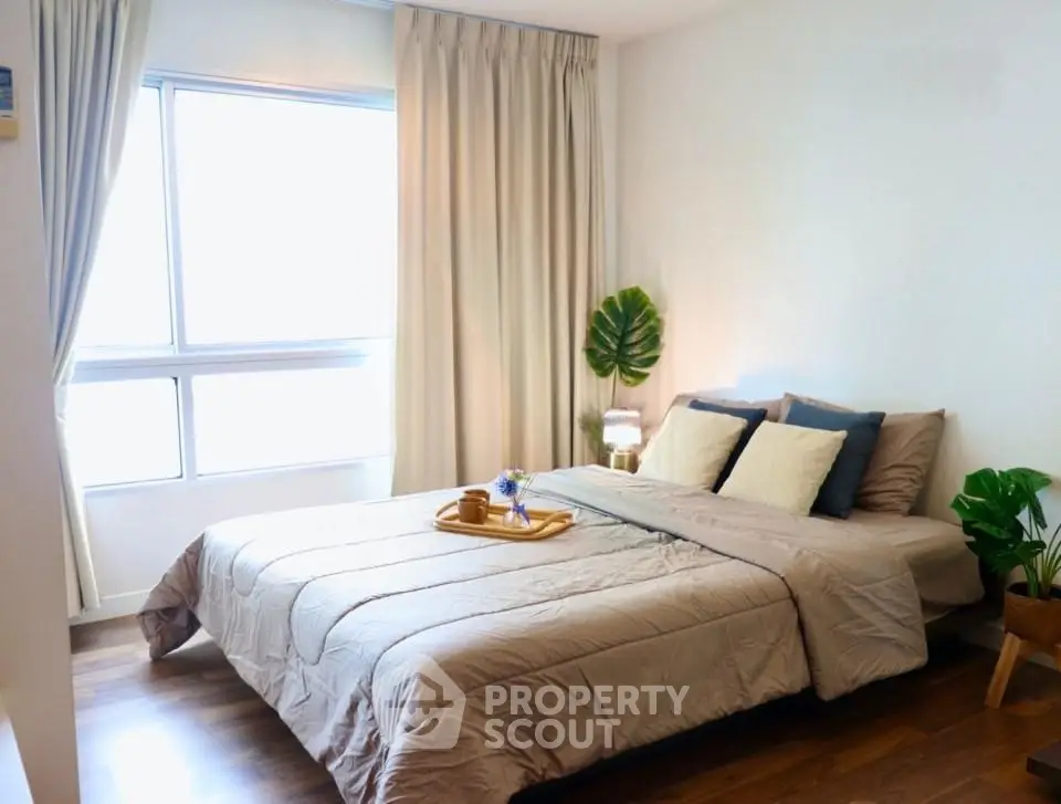 Cozy and inviting bedroom with large window and stylish decor, perfect for relaxation and comfort.