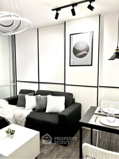 Modern living room with sleek black and white decor, cozy sofa, and stylish dining area.