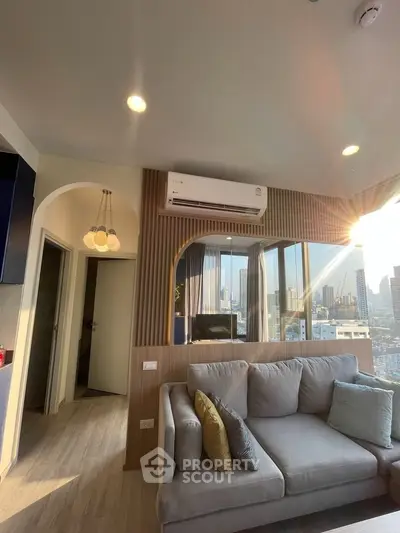 Modern living room with city view, featuring stylish sofa and air conditioning, perfect for urban living.