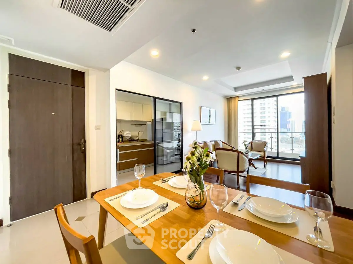 Modern open-plan living and dining area with city view, featuring elegant furniture and stylish decor.