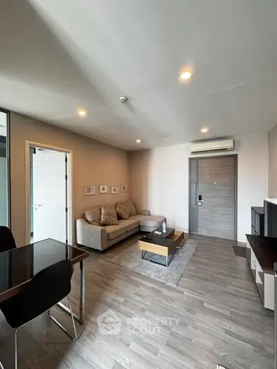 Modern living room with sleek furniture and wooden flooring in a stylish apartment.