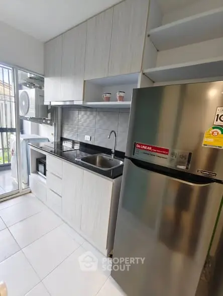 Modern kitchen with sleek cabinetry and stainless steel appliances in a compact layout.