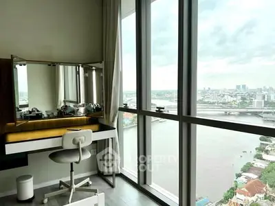 Stunning high-rise study with panoramic river view and modern desk setup.