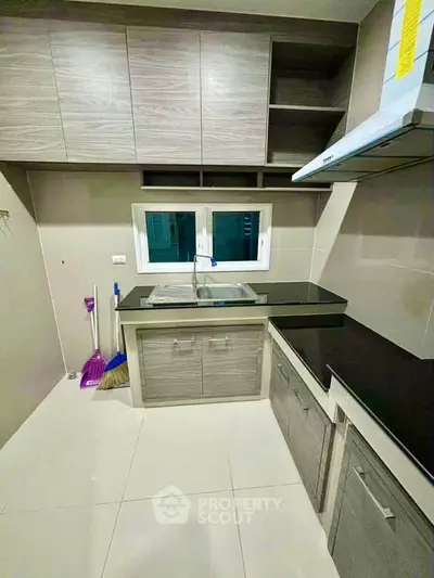 Modern kitchen with sleek cabinetry and black countertops