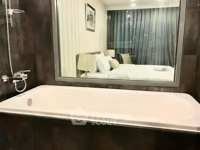 Luxurious bathroom with a bathtub and a view into a stylish bedroom, perfect for relaxation.