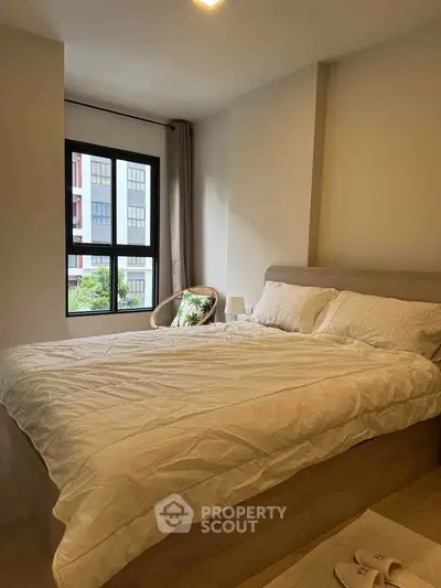 Cozy bedroom with large window and modern decor in a stylish apartment.