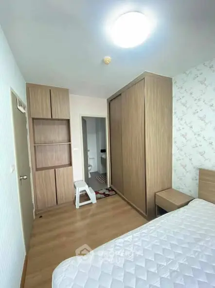 Cozy bedroom with wooden furniture and floral wallpaper, featuring a spacious wardrobe and comfortable bed.