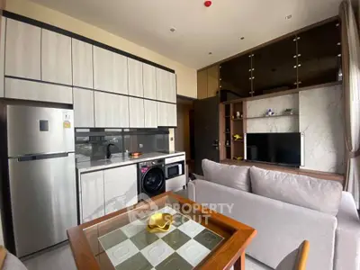 Modern open-layout kitchen and living room with sleek appliances and stylish decor.