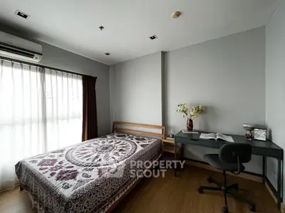 Cozy bedroom with natural light, featuring a bed, desk, and stylish decor, perfect for a serene living space.