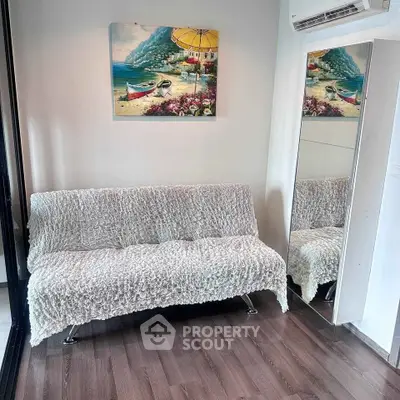 Cozy living room with stylish sofa and wall art, perfect for relaxation.
