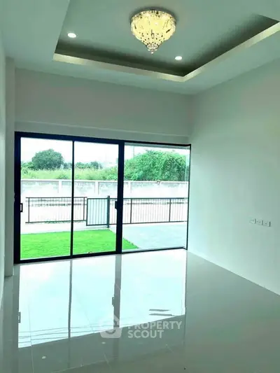 Spacious living room with large glass doors and modern chandelier