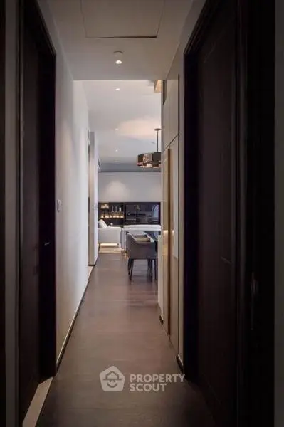 Elegant hallway leading to a modern living room with stylish decor and ambient lighting.