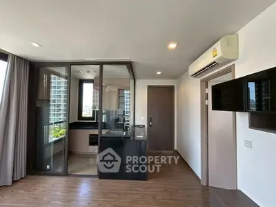 Modern apartment with glass-enclosed kitchen and sleek wooden flooring