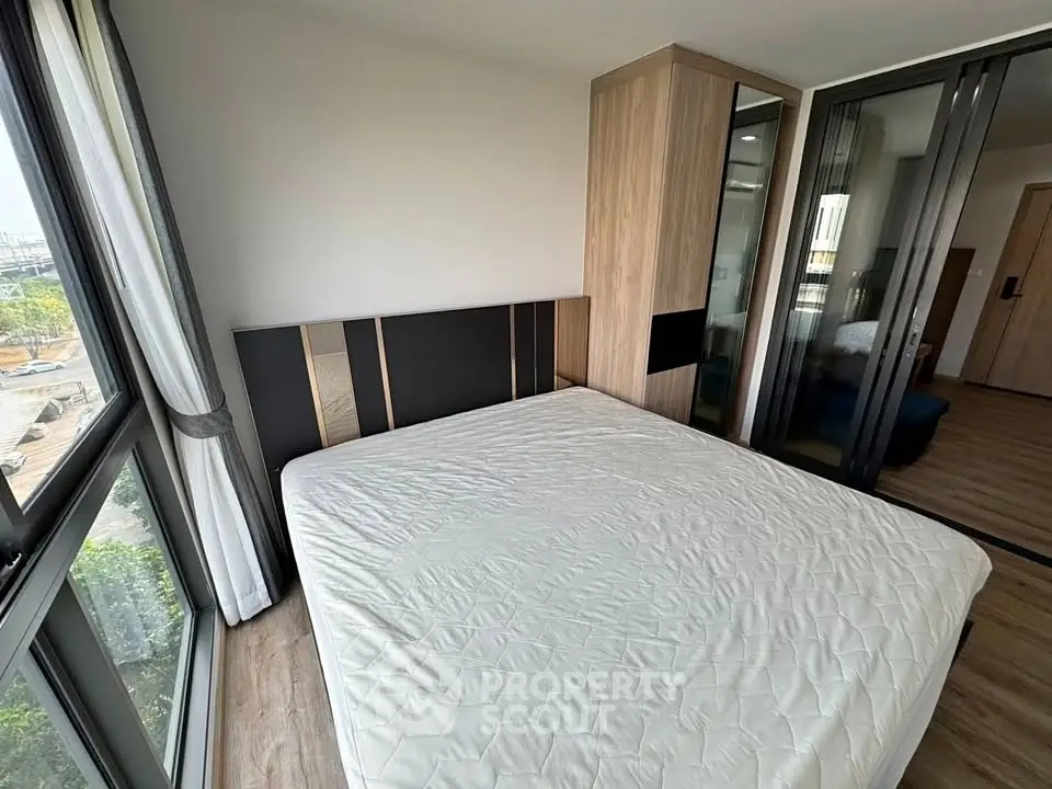 Modern bedroom with large windows and stylish wardrobe in a contemporary apartment.