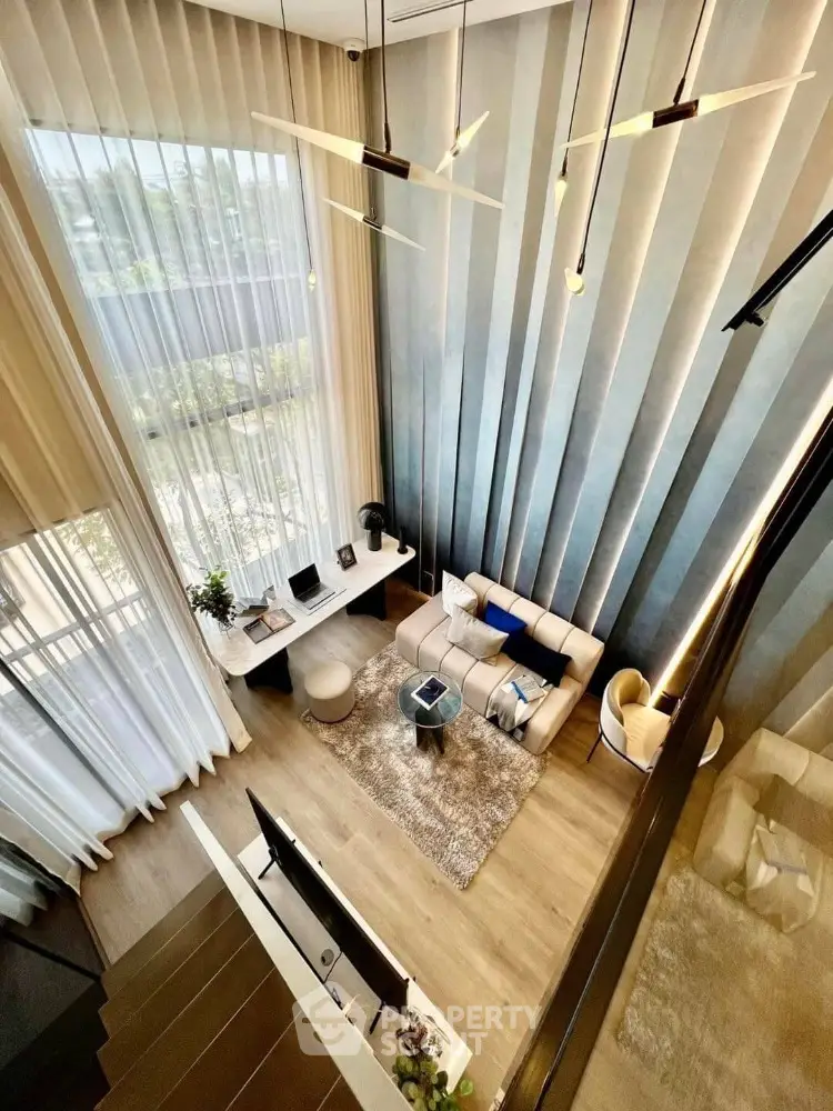 Luxurious double-height living room with floor-to-ceiling windows, modern furniture, and elegant lighting fixtures, creating a spacious and inviting atmosphere.