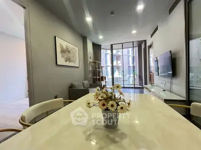 Modern living room with elegant decor and large windows offering natural light.