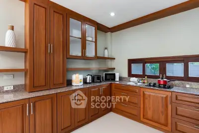 Spacious kitchen with wooden cabinets and modern appliances in a stylish home.