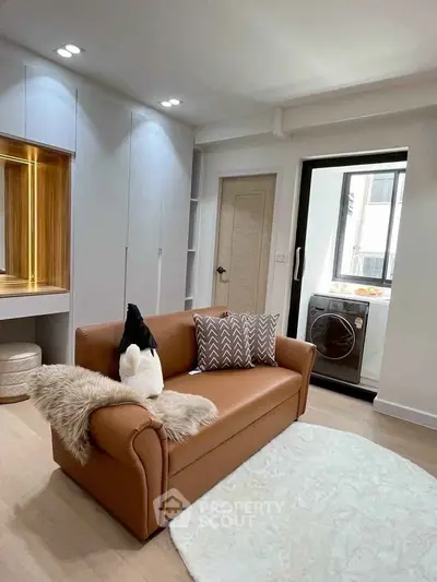 Modern living room with cozy sofa and washing machine in bright apartment