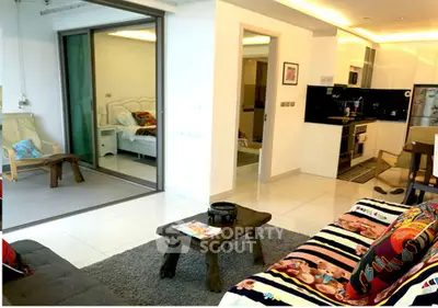 Modern open-plan living room with kitchen and bedroom view