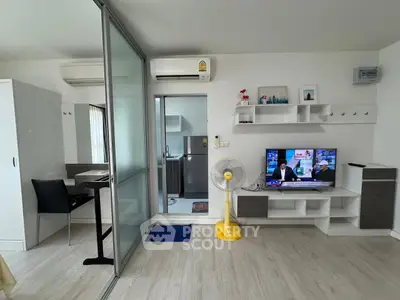 Modern living room with TV, air conditioning, and sliding glass door to kitchen.