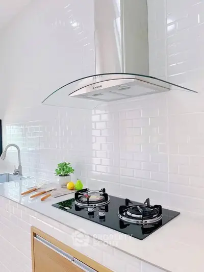Modern kitchen with sleek gas stove and white subway tile backsplash.