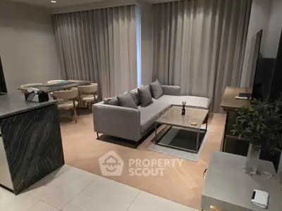 Modern living room with stylish gray sofa, sleek dining area, and elegant decor in a contemporary apartment.