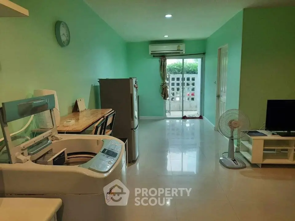 Spacious living room with modern appliances and balcony view