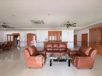 Spacious living room with leather sofas and elegant wooden cabinetry, perfect for entertaining guests.