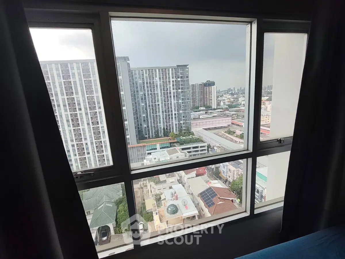 Stunning cityscape view from a high-rise apartment window, showcasing modern urban living.