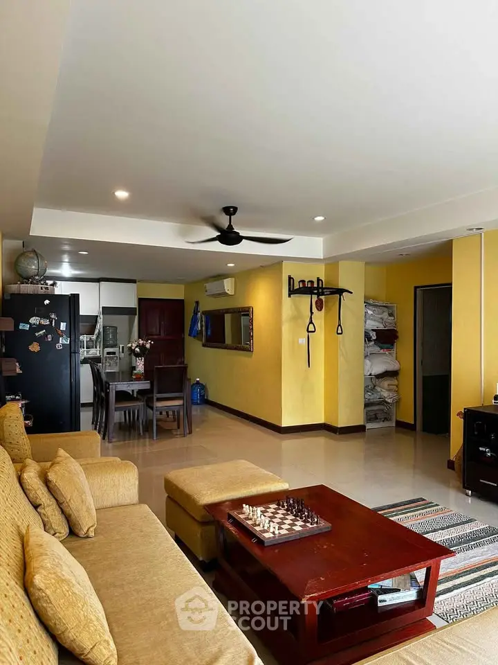 Spacious living room with modern decor and open layout, featuring a cozy seating area and dining space.